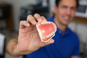 man holding dentures close up, Casa Grande, AZ dentures specialist